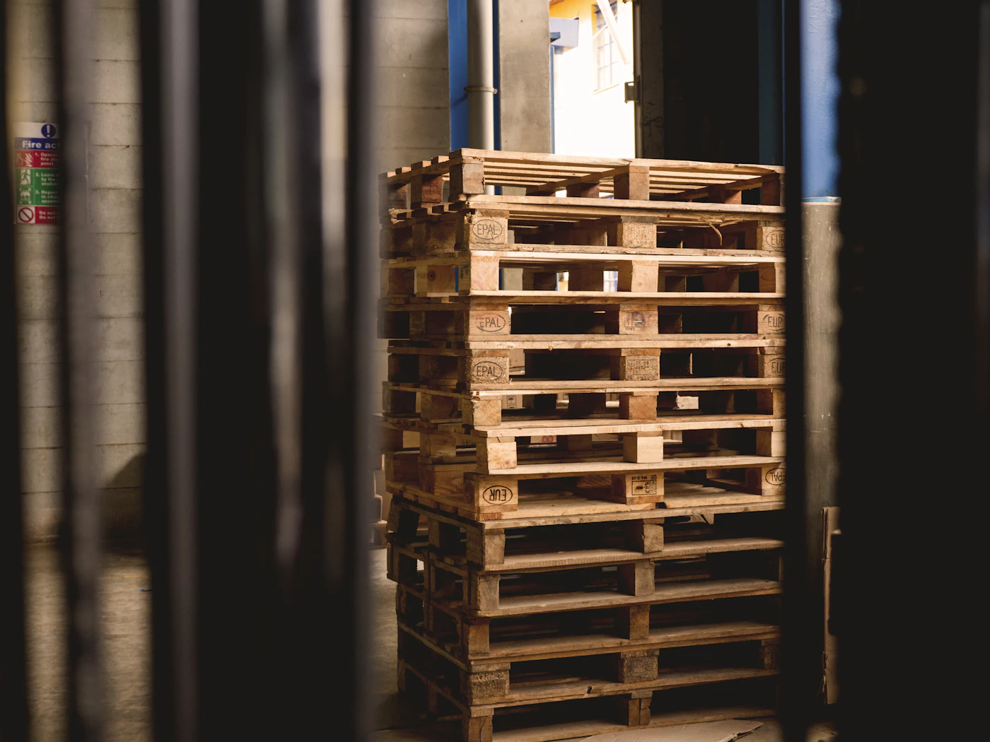 Palettes en bois empilées dans une zone de stockage