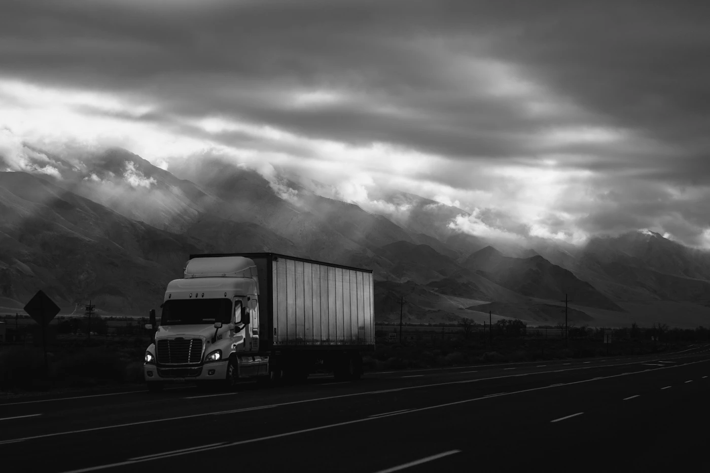 Camion blanc sur une route bordée de montagnes